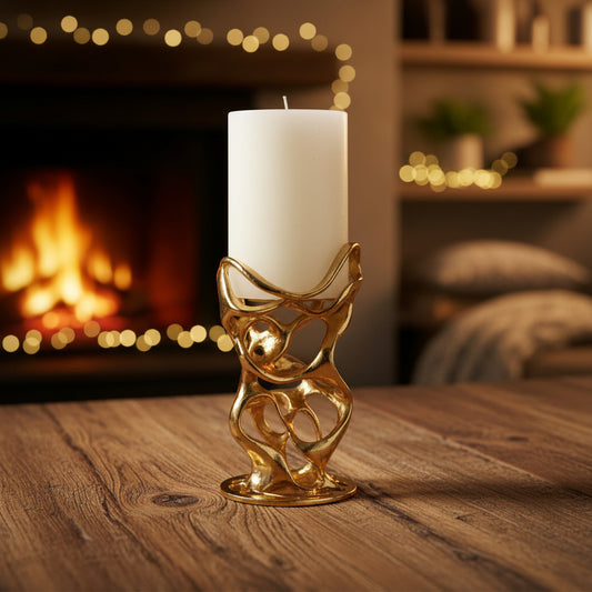 Gold candle holder with a white candle on a light gray background